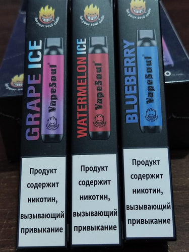 VapeSoul disposable vape devices in black, purple, and blue colors with flavor labels Grape Ice, Watermelon Ice, and Blueberry respectively, against a patterned background.